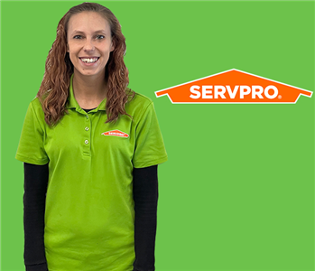 woman in front of SERVPRO green with logo