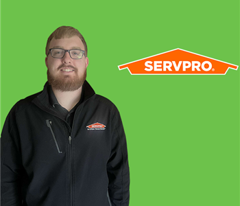 a man in front of a SERVPRO background