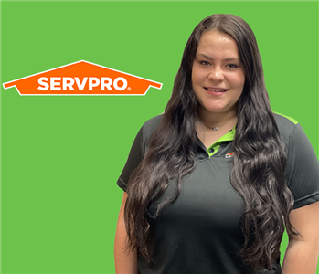 Girl in front of SERVPRO green with logo
