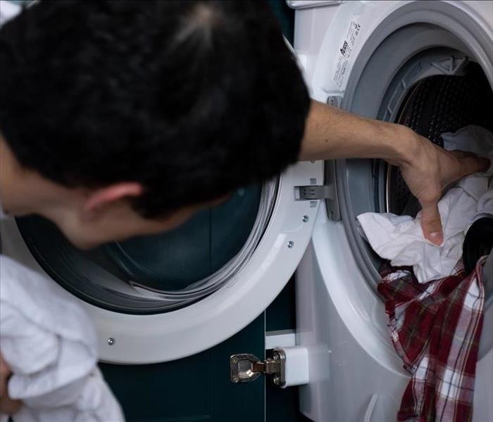 Man putting clothes in dryer