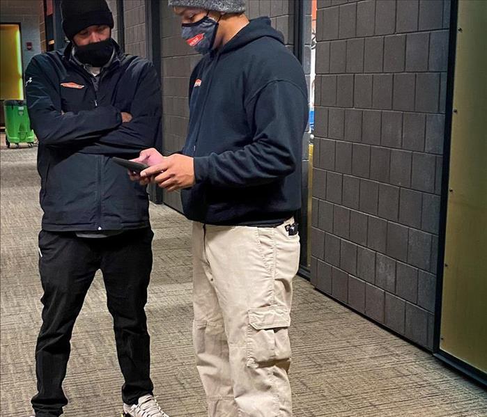 Two SERVPRO team members looking at an ipad